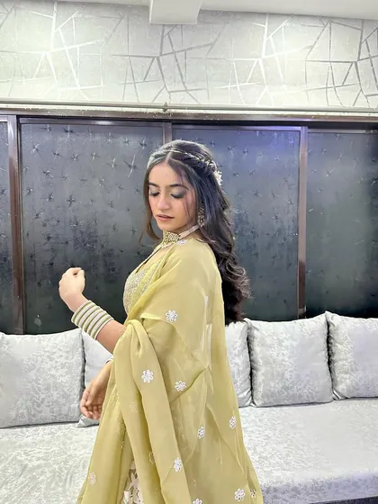 A side profile of this stunning guest. The braided hairstyle and soft makeup create a look that is both timeless and trendy.