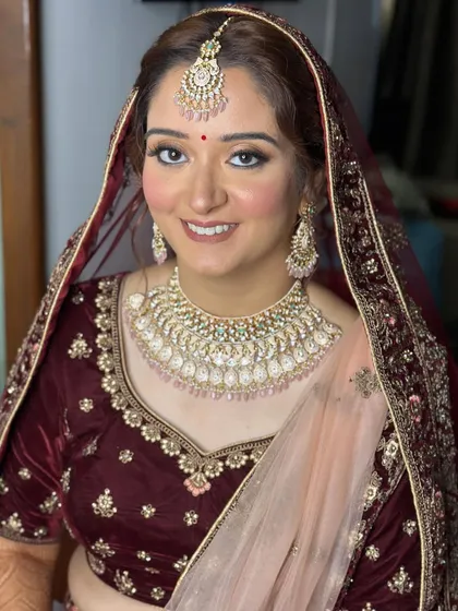 A classic bridal portrait. The makeup is perfectly set with a dupatta, showcasing a look that is both traditional and chic.