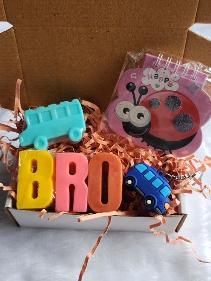 A closer look at a Rakhi hamper for a brother, featuring 'BRO' alphabet soaps, a bus-shaped soap, and other cute goodies to make him smile.