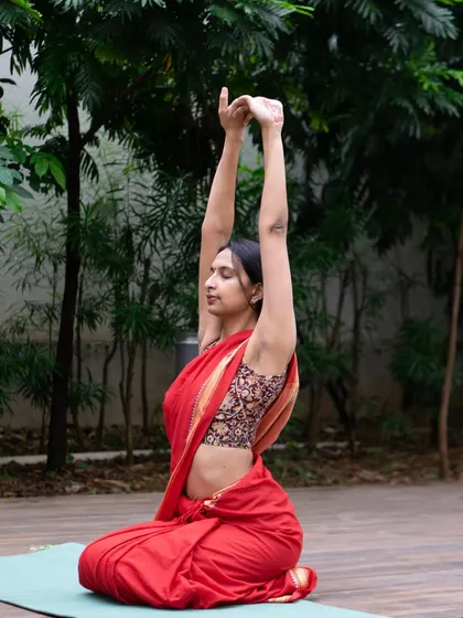 Yoga is a practice of both movement and stillness. Here, I am in a warm up stretch in Vajrasana, a simple seated pose. This demonstrates that the practice is not about being in fancy clothes, but about finding comfort and relaxation wherever you are.