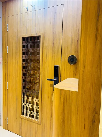A close-up of the safety door, showing the detail of the wood grain laminate and the modern black digital lock.