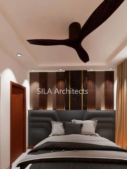 A bedroom design for the JP Nagar project, featuring a dark, sophisticated color palette with an upholstered headboard and dramatic lighting.