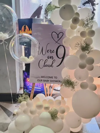 This 'We're on Cloud 9' baby shower theme uses an all-white balloon garland dotted with delicate baby's breath flowers. The welcome sign on the easel and the clear bubble balloons with 'cloud' stuffing complete this dreamy and elegant look.
