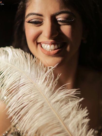 A beautiful, smiling close-up of the bride, her joy evident, with a feather adding a soft, artistic touch.