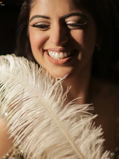 A beautiful, smiling close-up of the bride, her joy evident, with a feather adding a soft, artistic touch.