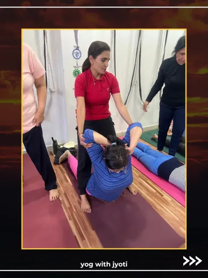 A hands-on adjustment in a backbend helps the student to open her chest and shoulders safely.