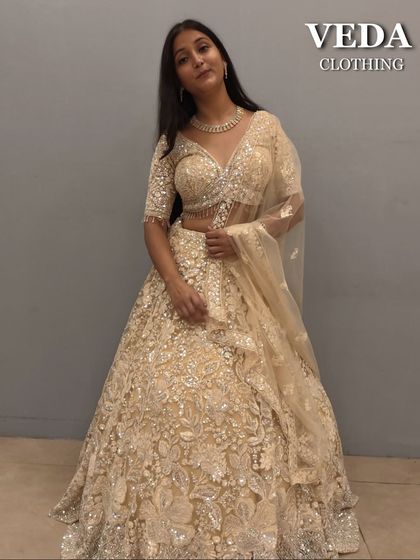 A full-length view of the cream and gold lehenga, showcasing its grand and luxurious feel.