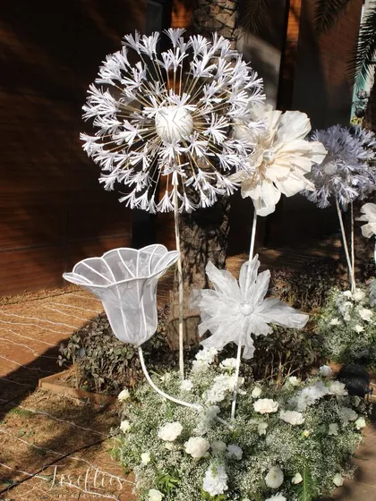 A close-up of the handcrafted, larger-than-life paper flowers used in the 'White Wonderland' decor. These artistic pieces were a central element of the theme.