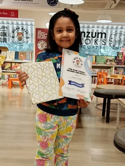 Celebrating a milestone. This young reader is proudly showing off her 'Blue Stripes' reader certificate and a well-earned surprise gift. It's so rewarding to see their confidence grow with every book they finish.
