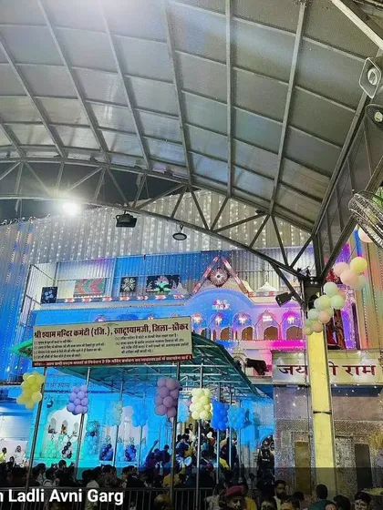 The exterior view of the temple decorated for a Khatu Shyam Ji event. The building was lit up beautifully, and we added balloons to enhance the festive look.