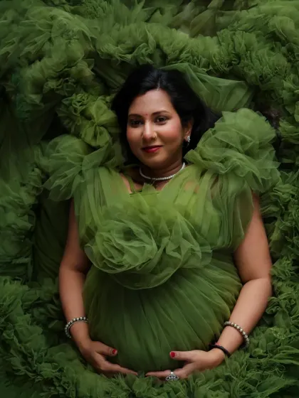 An artistic overhead shot in our olive green ruffled gown. The fabric creates a stunning floral pattern, turning your portrait into a piece of art.