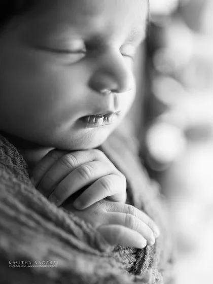 A black and white macro shot of a newborn's hands and mouth. These images magnify the tiniest wonders, creating a powerful and emotional memory.