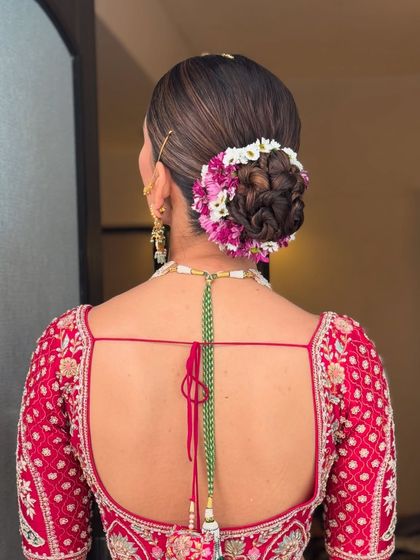 A detailed shot of the floral bun, showcasing the texture of the hair and the careful placement of each flower. I ensure the flowers stay fresh and vibrant for hours.