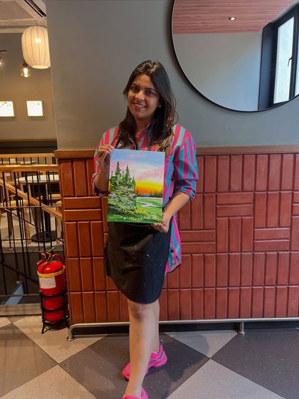 A proud artist with her serene sunset landscape painting. It's so rewarding to see people discover their creative side in my workshops.