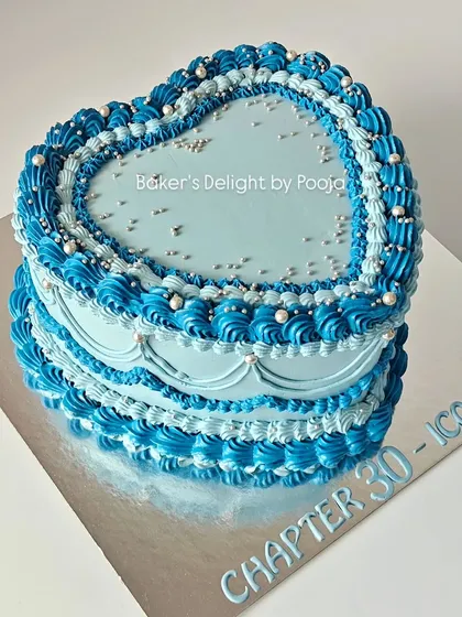Turning 30 in style with this dreamy vintage-style heart cake. The Lambeth-style piping in shades of blue, accented with silver pearls, creates a chic and timeless look.