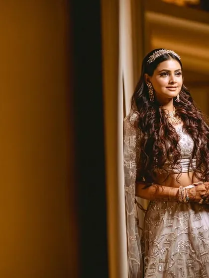 A quiet, elegant portrait of the bride leaning against a wall, the soft lighting highlighting her features.
