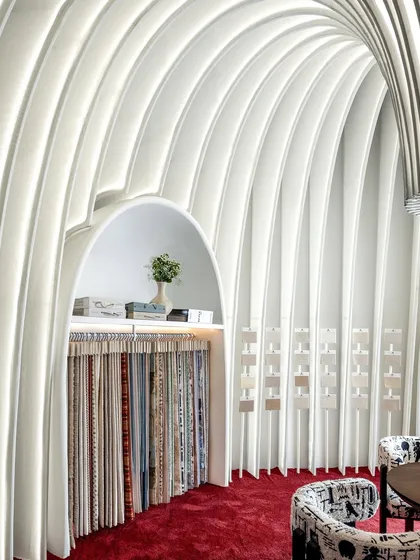 A detail of the curved walls and the integrated display niche. We let the fabric architecture create its own functional spaces, seamlessly blending product display with the overall artistic concept.
