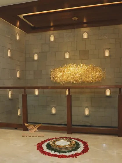 A stunning view of a home's interior during a house warming, with a floral rangoli and an elegant chandelier, creating a grand and auspicious ambiance.