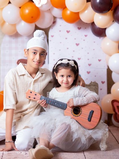 A fun sibling portrait with a little guitar prop. Adding simple props can bring out kids' personalities and lead to adorable, playful photos.