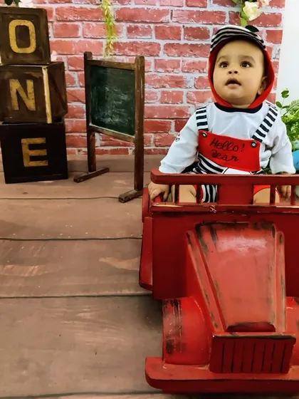 Ready to roll into year two. This image shows our red truck prop paired with the rustic schoolhouse "ONE" blocks, offering a playful and classic look for a first birthday.