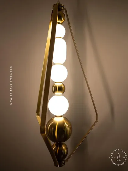 This elegant pendant features a unique triangular gold frame holding a series of glowing orbs. It serves as a sculptural art piece, ideal for adding a touch of sophistication to a reading nook or a small entryway.