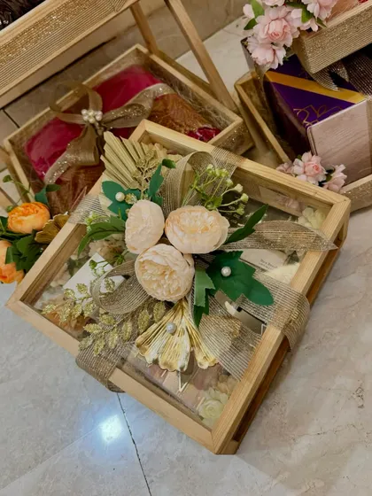 This glass-lidded wooden box is perfect for showcasing delicate items in a wedding trousseau, beautifully decorated with peonies and burlap ribbon.