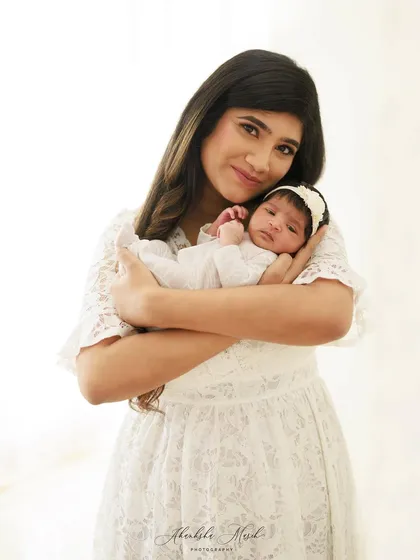 There is nothing more precious than the first few weeks with your newborn. This portrait captures the serene, gentle love of a mother holding her new baby close.