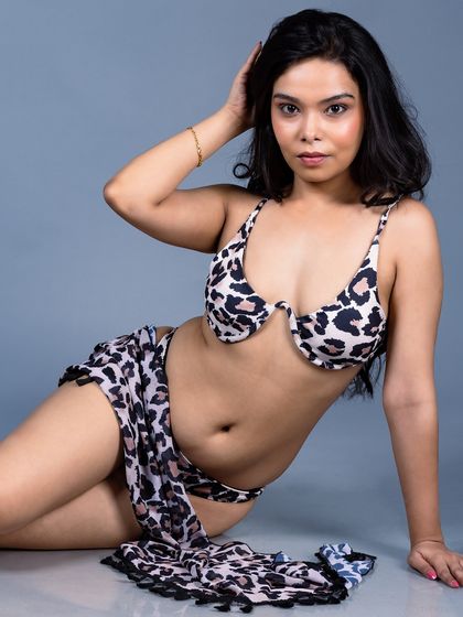 A relaxed, seated pose in the animal print bikini.