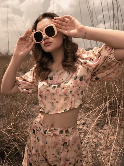 A playful, sun-drenched shot focusing on the floral co-ord set and sunglasses. This image captures a youthful, carefree vibe, perfect for a social media campaign.