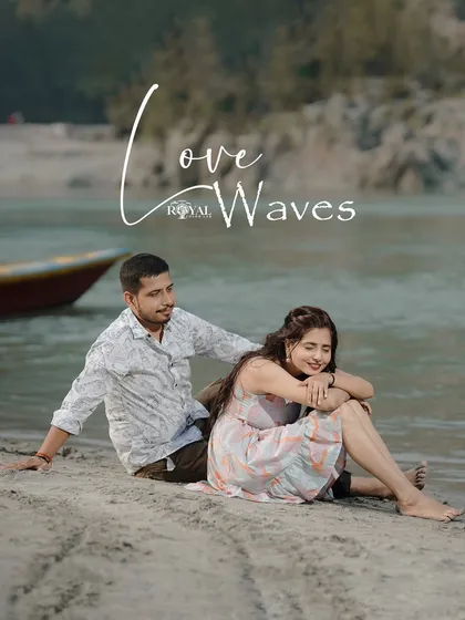 A sweet shot of a couple sitting on the sand by the river, titled 'Love Waves', perfectly capturing a relaxed beach vibe.