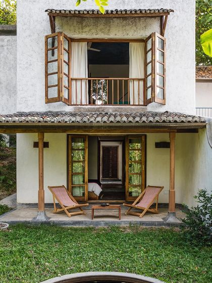 A view of the Tower Room and Garden Room exteriors, showing the combination of white lime-plastered walls, wooden balconies, and traditional tiled roofs.