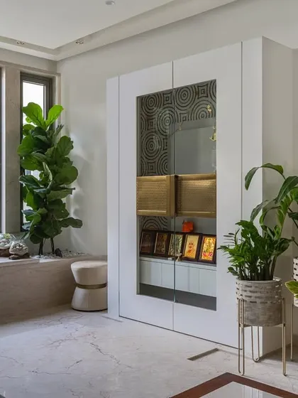 Creating a sacred space within a home is a special responsibility. This Vastu-compliant temple area from our 'Enchanted Eco' project uses clean white lines, natural light, and lush greenery to create a serene and tranquil corner for meditation and peace.