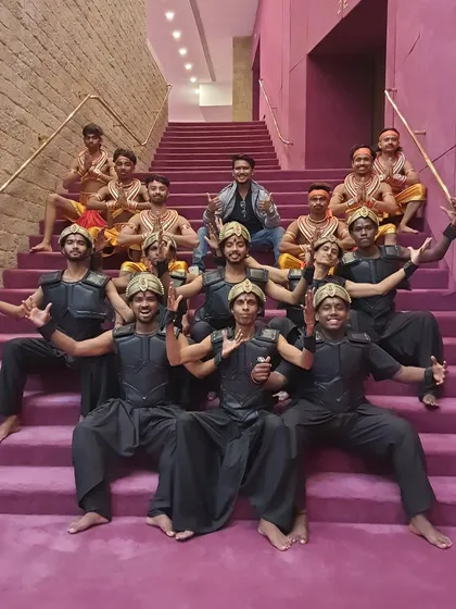 The team of dancers posing on the grand staircase of the theatre. Being part of such a massive production is a testament to our team's capability and dedication.