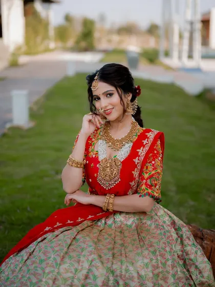 A smiling portrait of actress Niveditha Gowda in a beautiful half saree. This shot captures her personality and the elegance of the traditional attire in a natural outdoor setting.