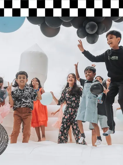 Kids having a blast in an all-white bouncy castle. I provide entertainment options that fit the event's aesthetic, like this chic and modern inflatable.