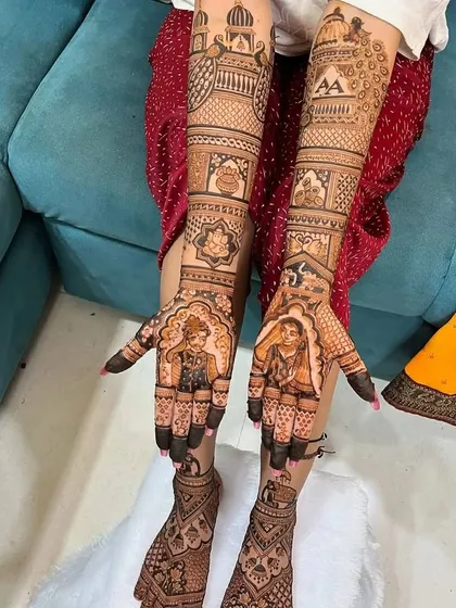 A full bridal set featuring custom portraits of the bride and groom on the palms. The design extends to the feet, maintaining a consistent theme with traditional motifs and the couple's initials.