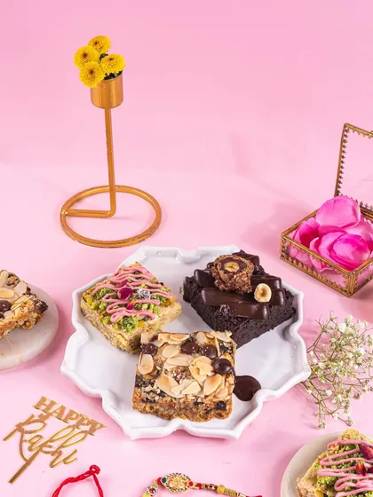 A beautiful flatlay of Rakhi treats on a floral plate. The pink background and scattered petals create a soft, feminine aesthetic that’s perfect for the occasion.