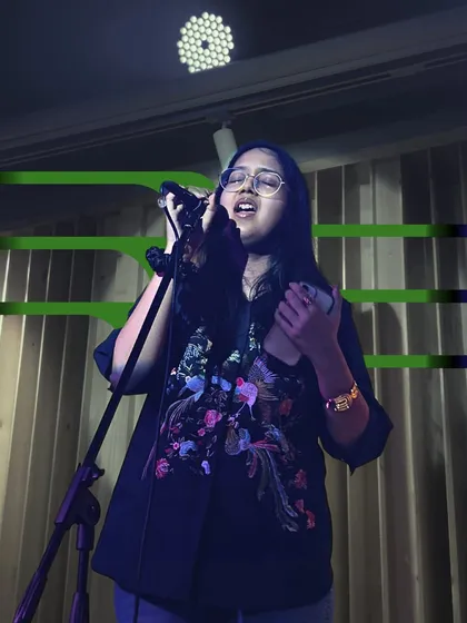 A singer connecting with the audience. We teach our students that performance is about more than just hitting the right notes; it's about communication.