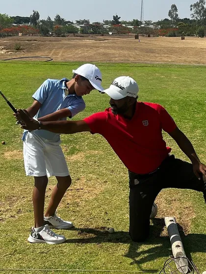 Another angle of a coach providing instruction to a young player. This foundational work is the most important part of their development.