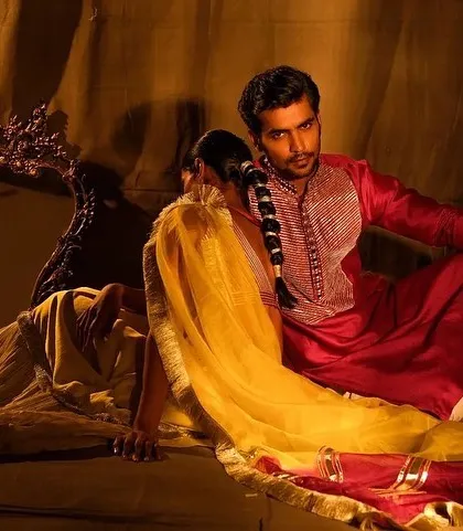 A wide shot that captures the grandeur and mood of a traditional setting. The makeup on the couple is designed to look flawless even from a distance, ensuring they look perfect in every frame.