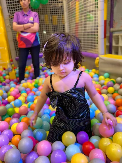 A little one exploring the textures and colors of the ball pit, a great sensory experience for toddlers.