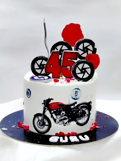 A cake for a Royal Enfield bike rider, featuring edible wheels and a printed image of the classic bike.
