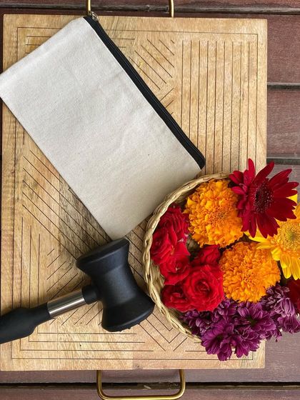 The simple tools of our craft: a canvas pouch, a basket of fresh flowers, and a mallet. With these, participants can create a unique and personal piece of art to take home.