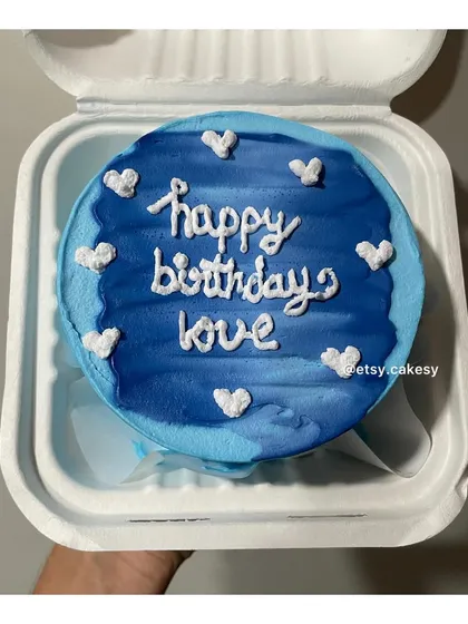 A beautiful blue watercolor-effect bento cake with 'happy birthday love' written in white frosting.
