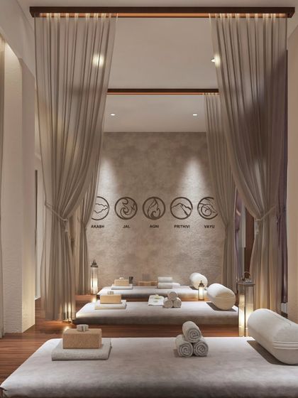 This relaxation lounge uses flowing curtains to create semi-private zones for guests. The design allows for both shared and personal moments of peace, with soft lighting and comfortable beds for post-treatment rest.