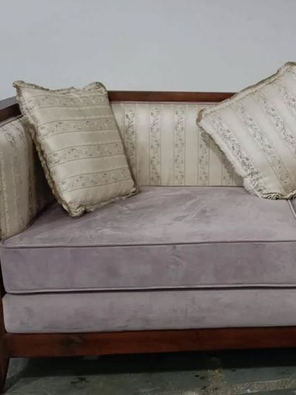 A workshop view of our wood-framed sofa, showcasing the rich grain of the timber and the plushness of the seat cushions. This piece is designed for clients who appreciate the beauty of natural materials.