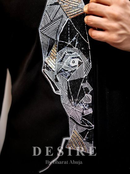 The craftsman's hand is visible in every stitch. This detail shot shows the intricate line work and sequin detailing that make up the geometric face motif on this unique designer shirt.