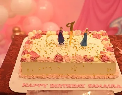 The birthday cake for Samaira's party, topped with Frozen figurines, blending two popular princess themes.