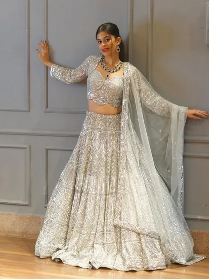 Sparkle bright in our all-new exclusive pieces. This full silver sequin lehenga with a long-sleeved blouse is the definition of glamour, perfect for a reception bride.