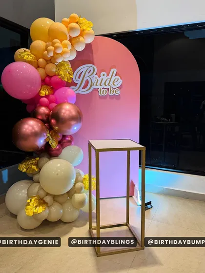 A chic "Bride to be" setup for a bridal shower. The pink backdrop and warm-toned balloon garland create a stylish and celebratory photo spot.